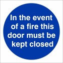 In The Event Of A Fire This Door Must Be Kept Closed mandatory sign with white text on a blue circular background